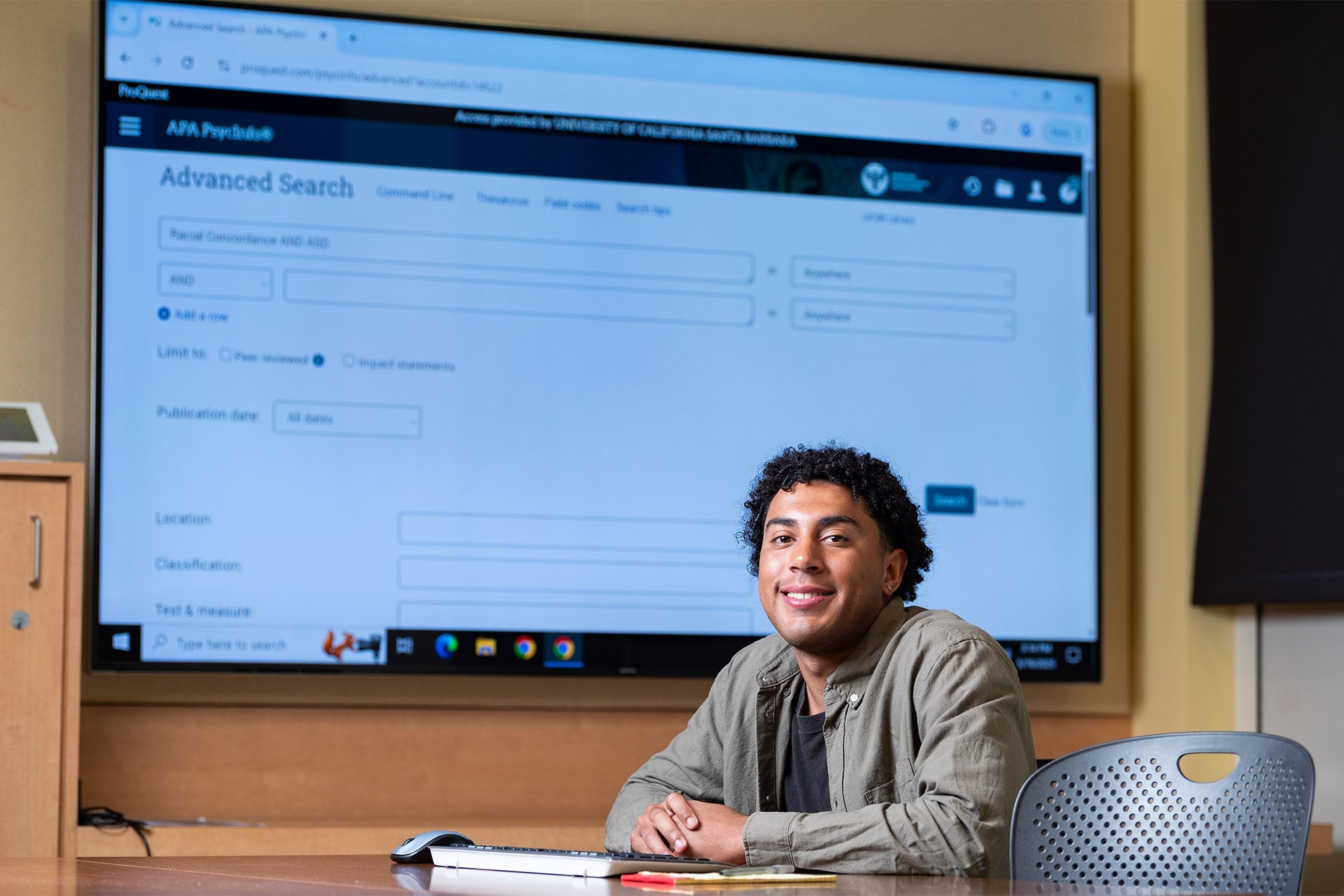 color photograph of a student in front of a large digital instructional screen