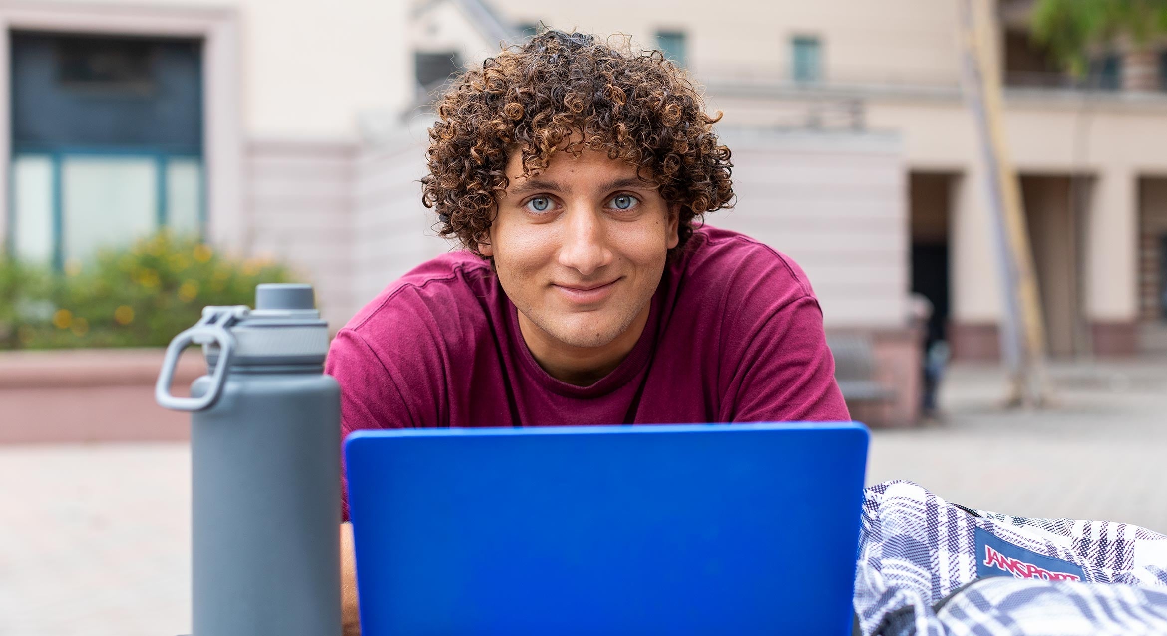 man with blue eyes in front of a blue laptop