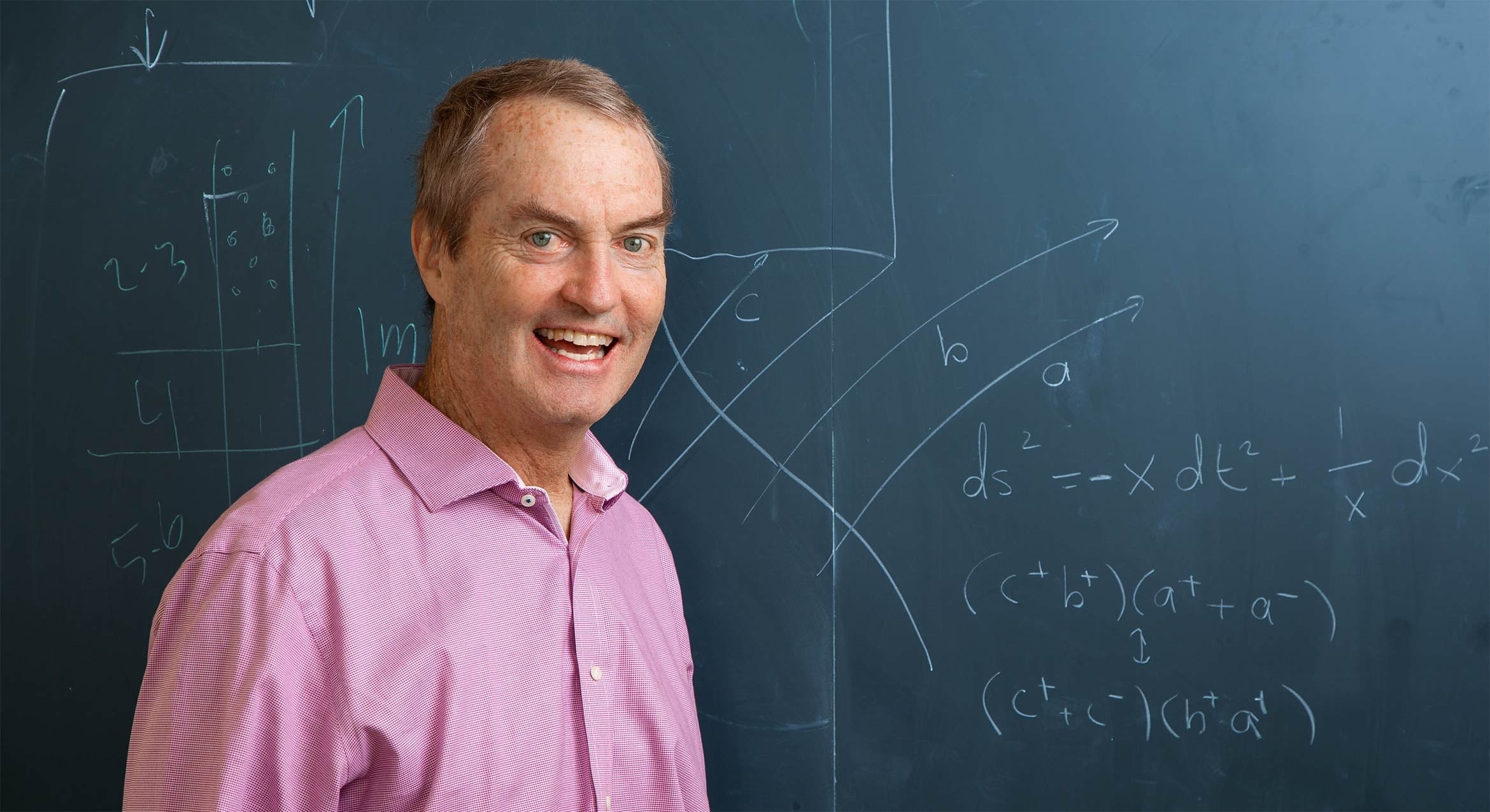 white man in front of blackboard 