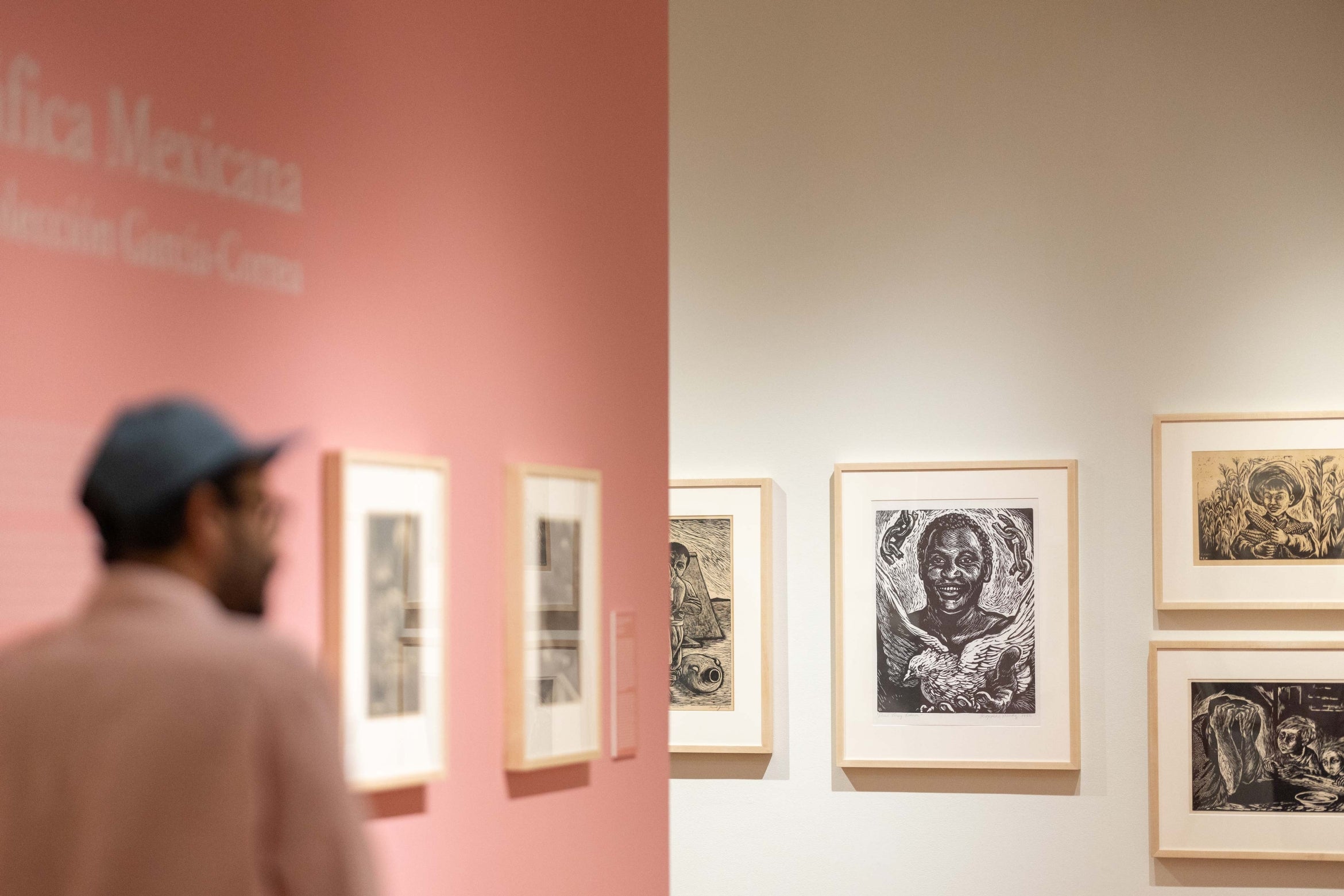 framed artwork in a gallery with man walking