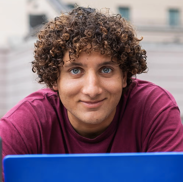 man with blue eyes in front of a blue laptop 