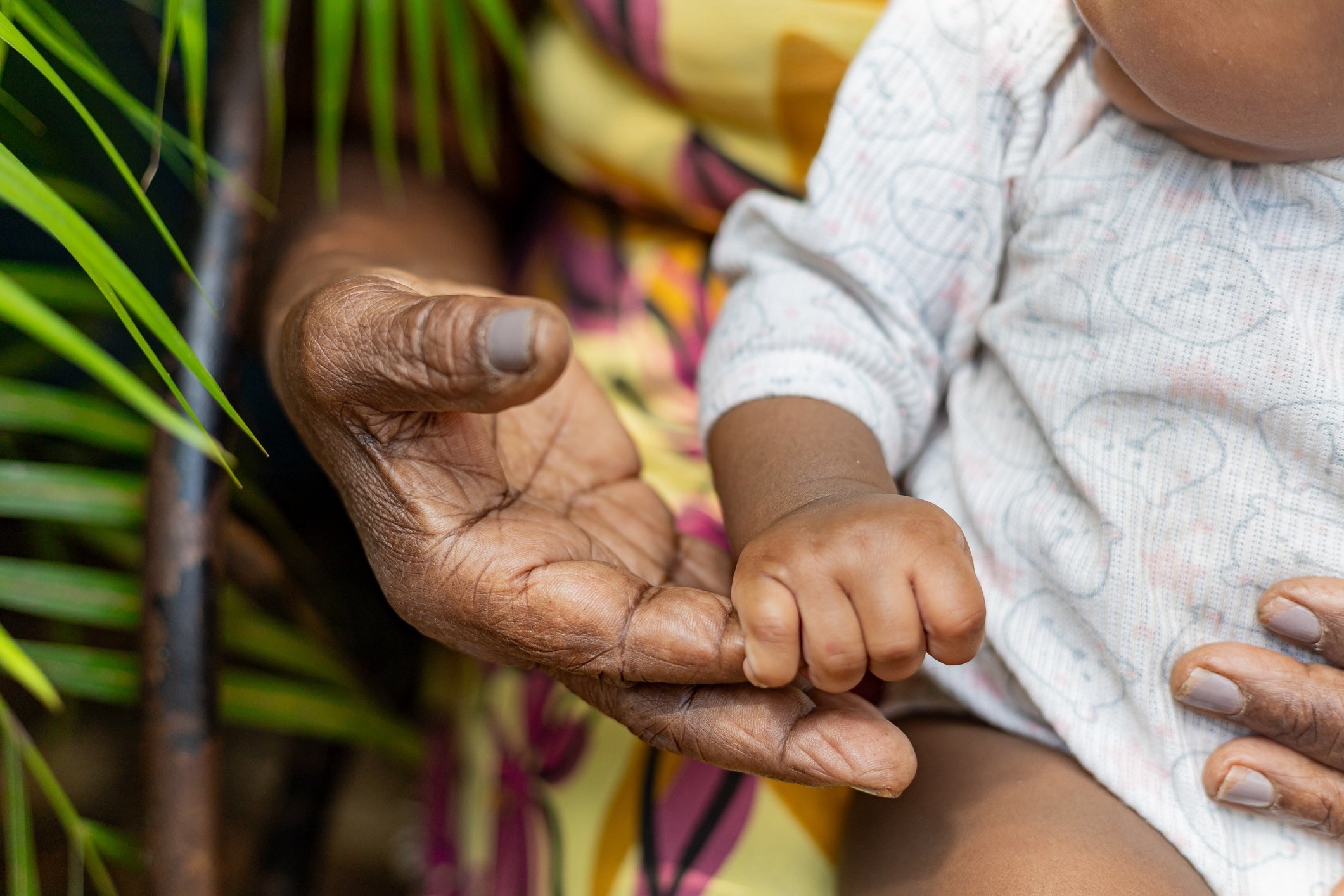 baby and grandmother holding hands