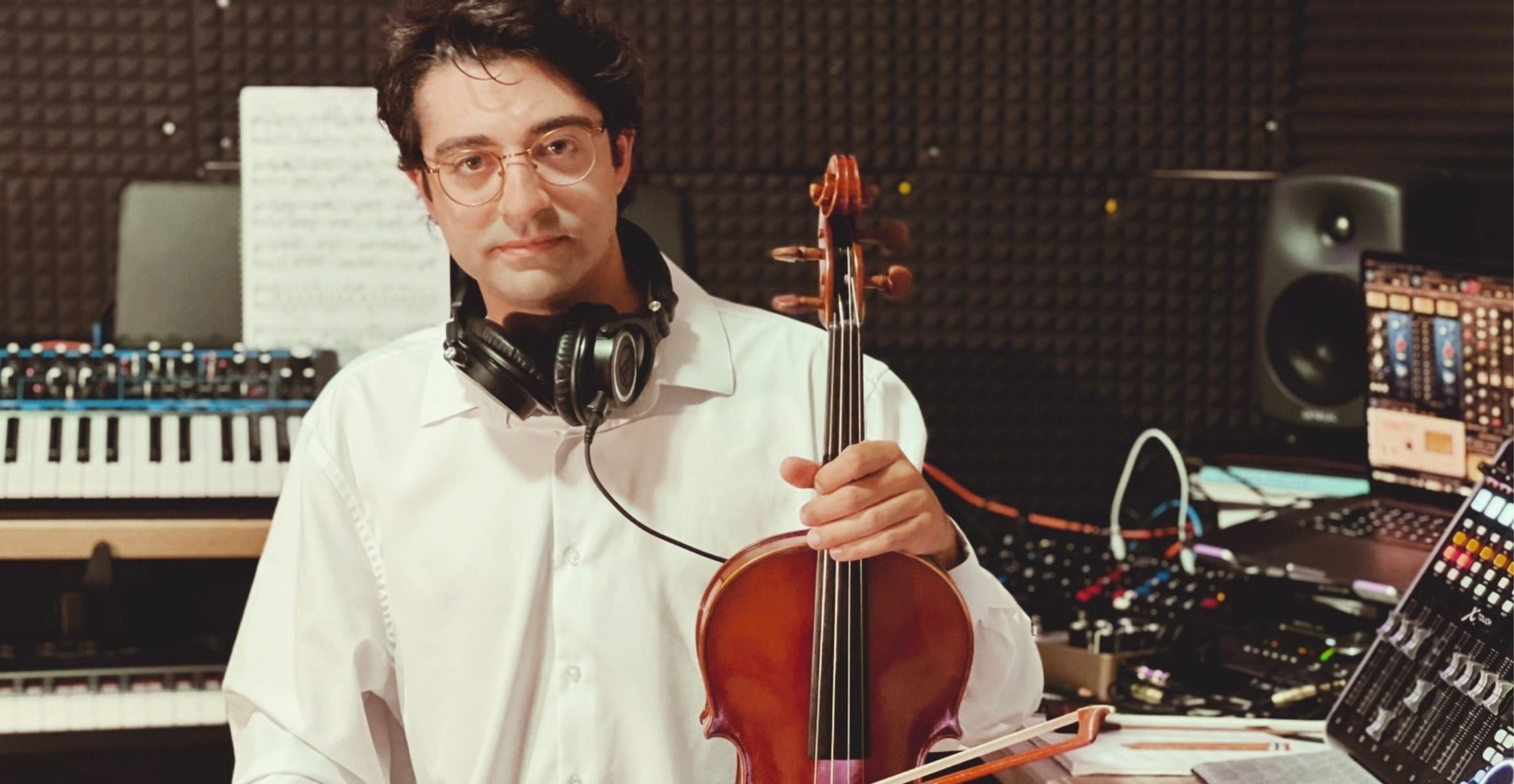 color photograph of musician Deniz Çağlarcan holding a violin 