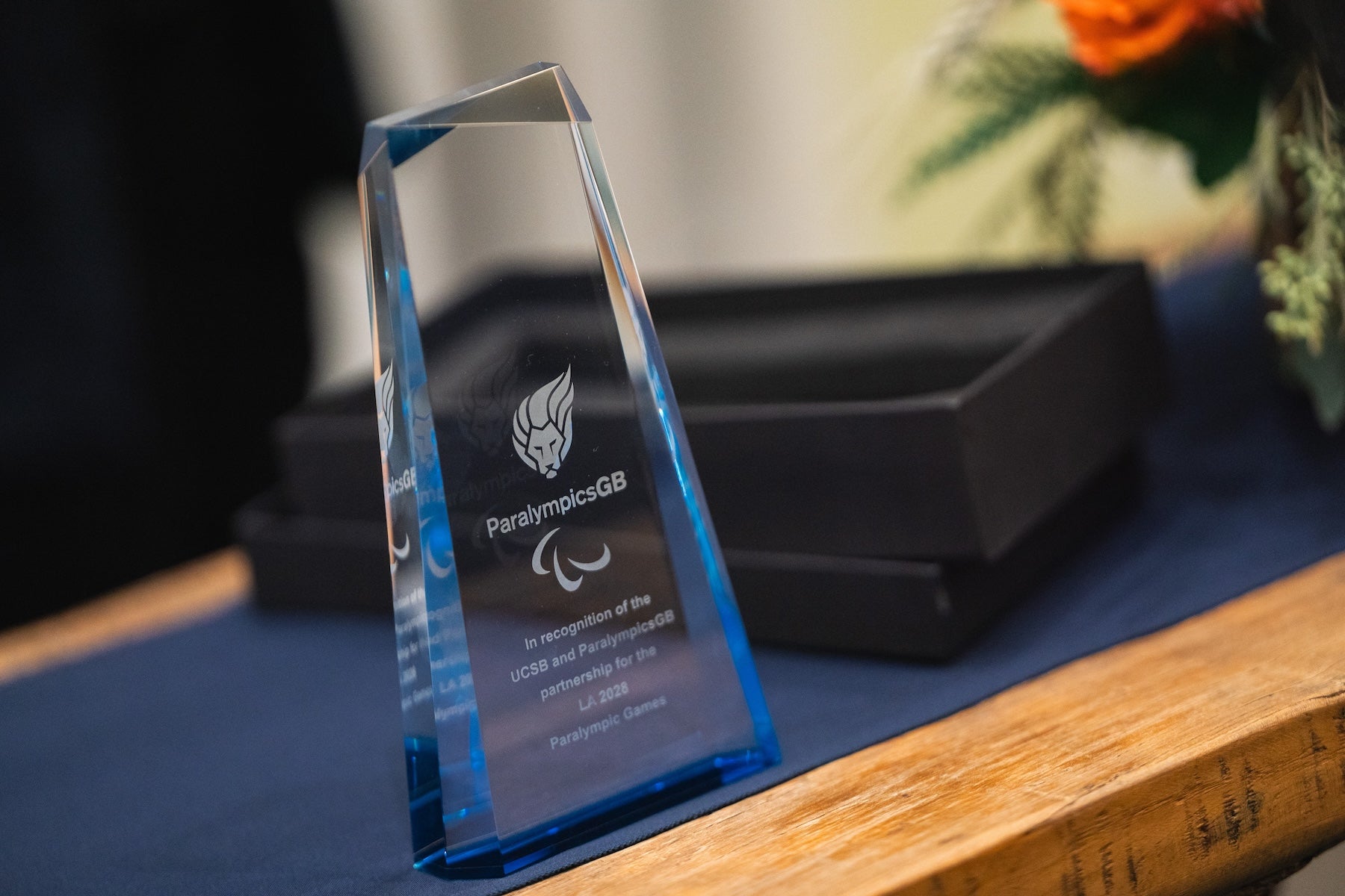 A glass statuette sits on a dark table
