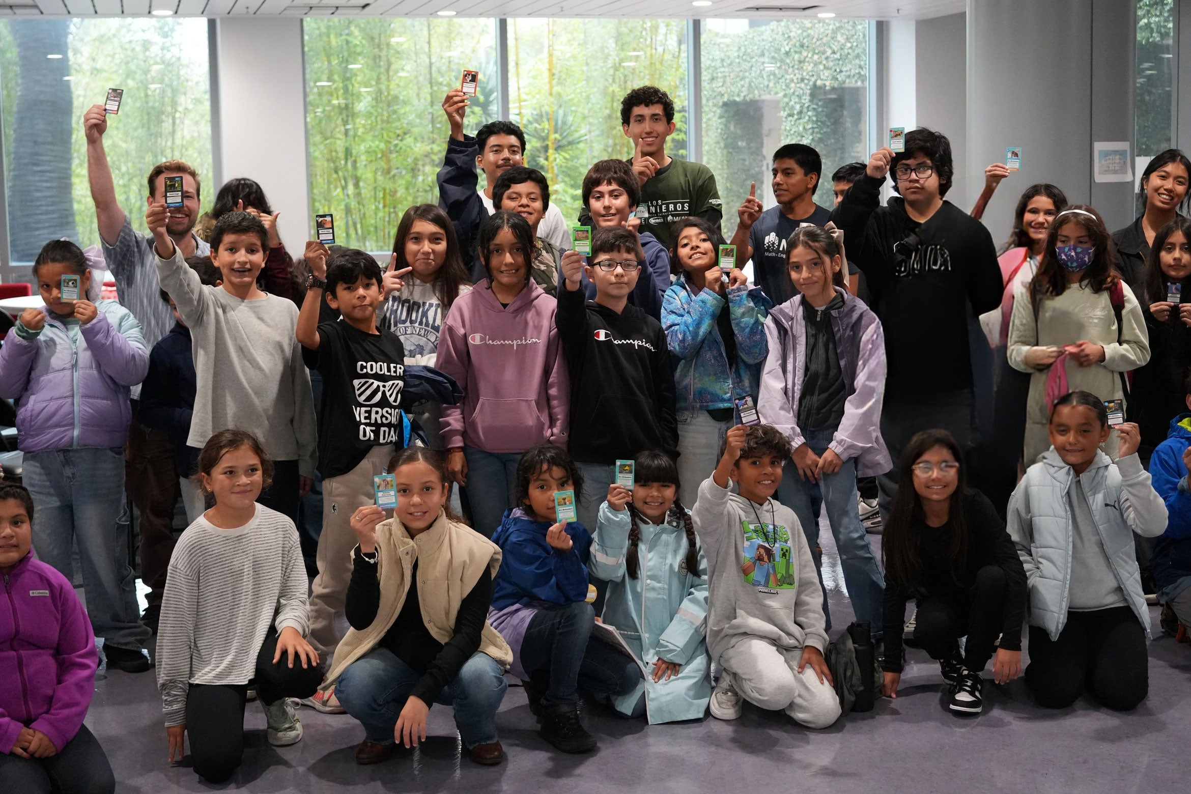 group of kids taking class photo holding cards
