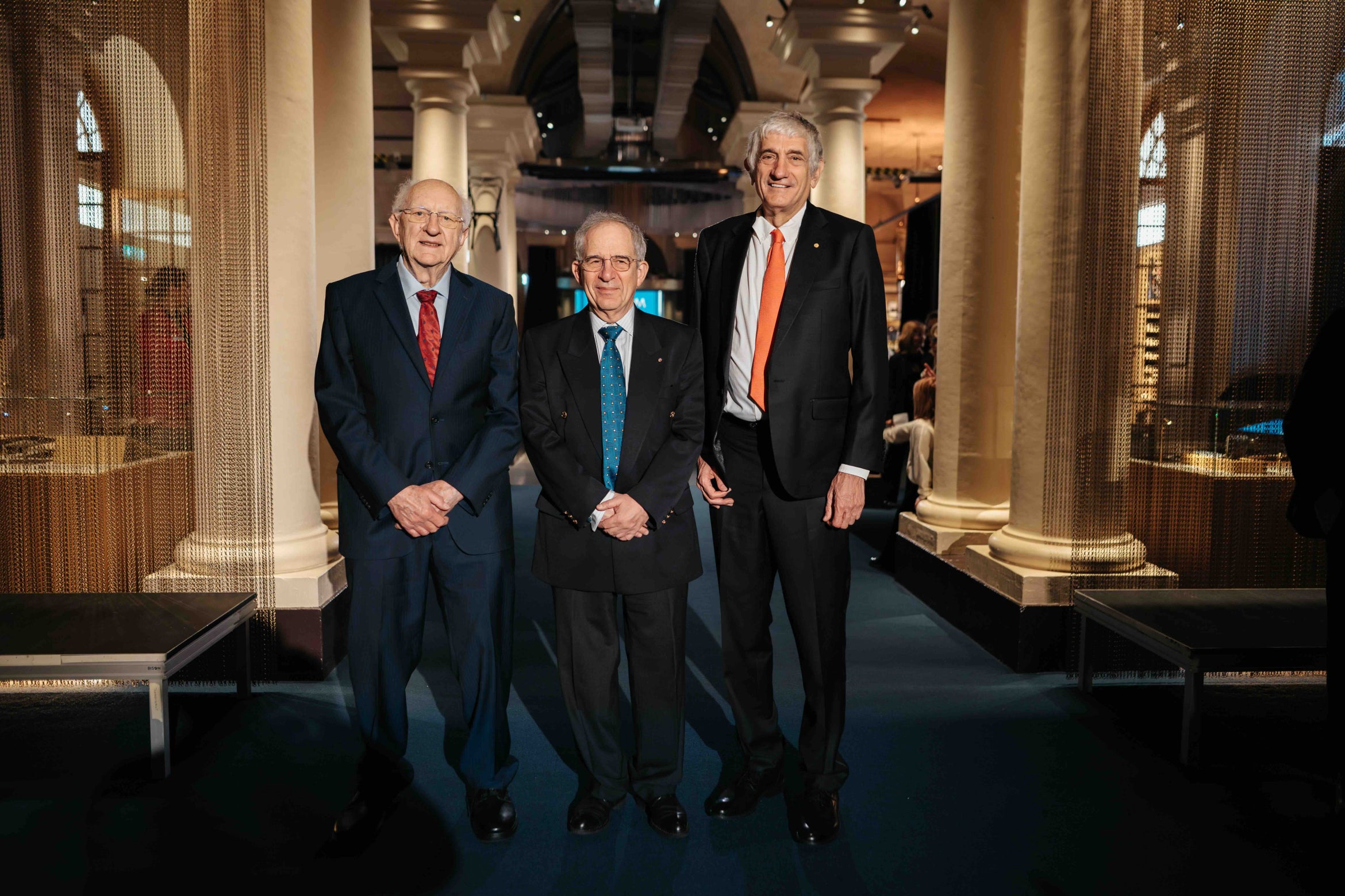 three men in suits in a beautiful hall