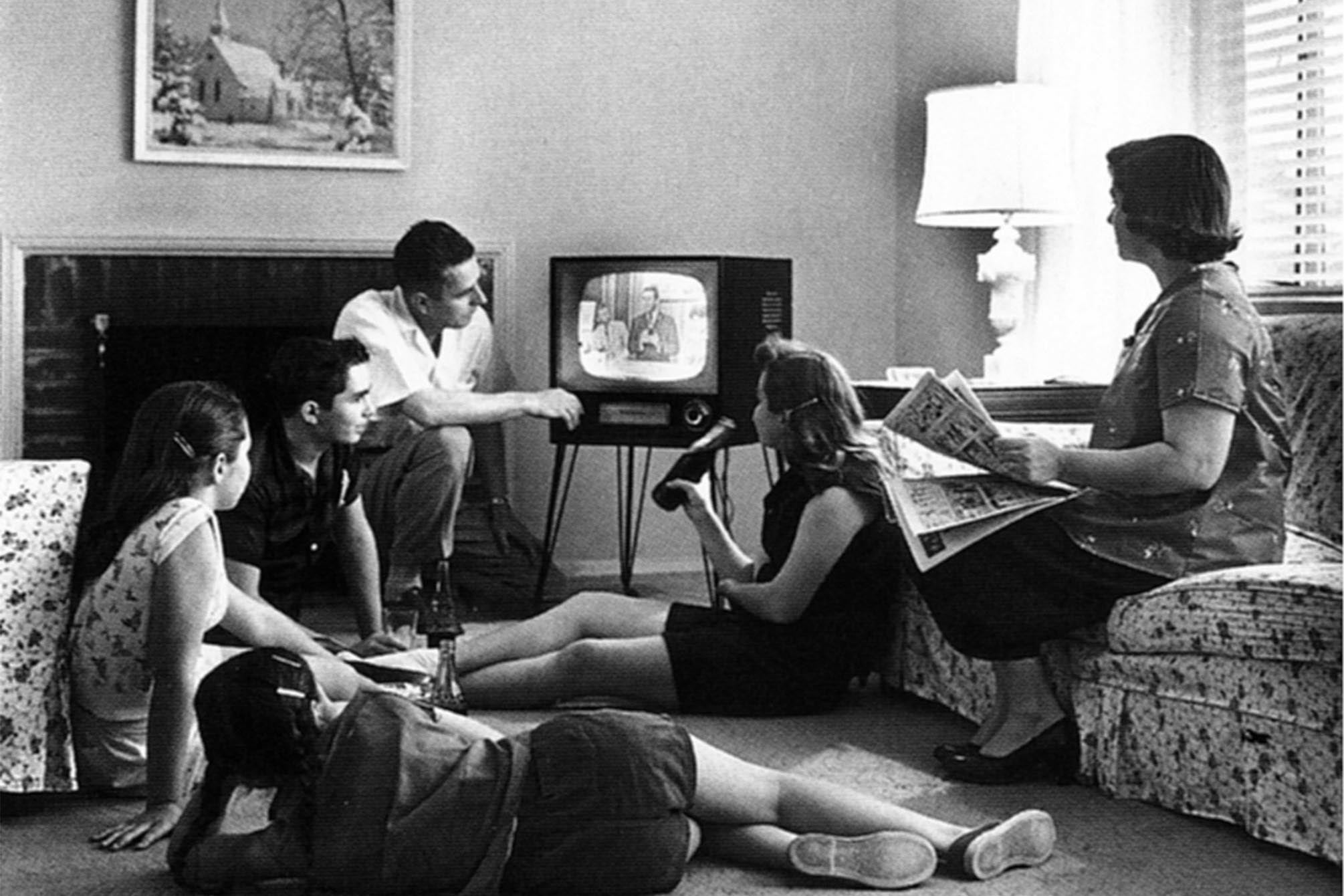 black and white photograph of a family watching television in the late 1950s