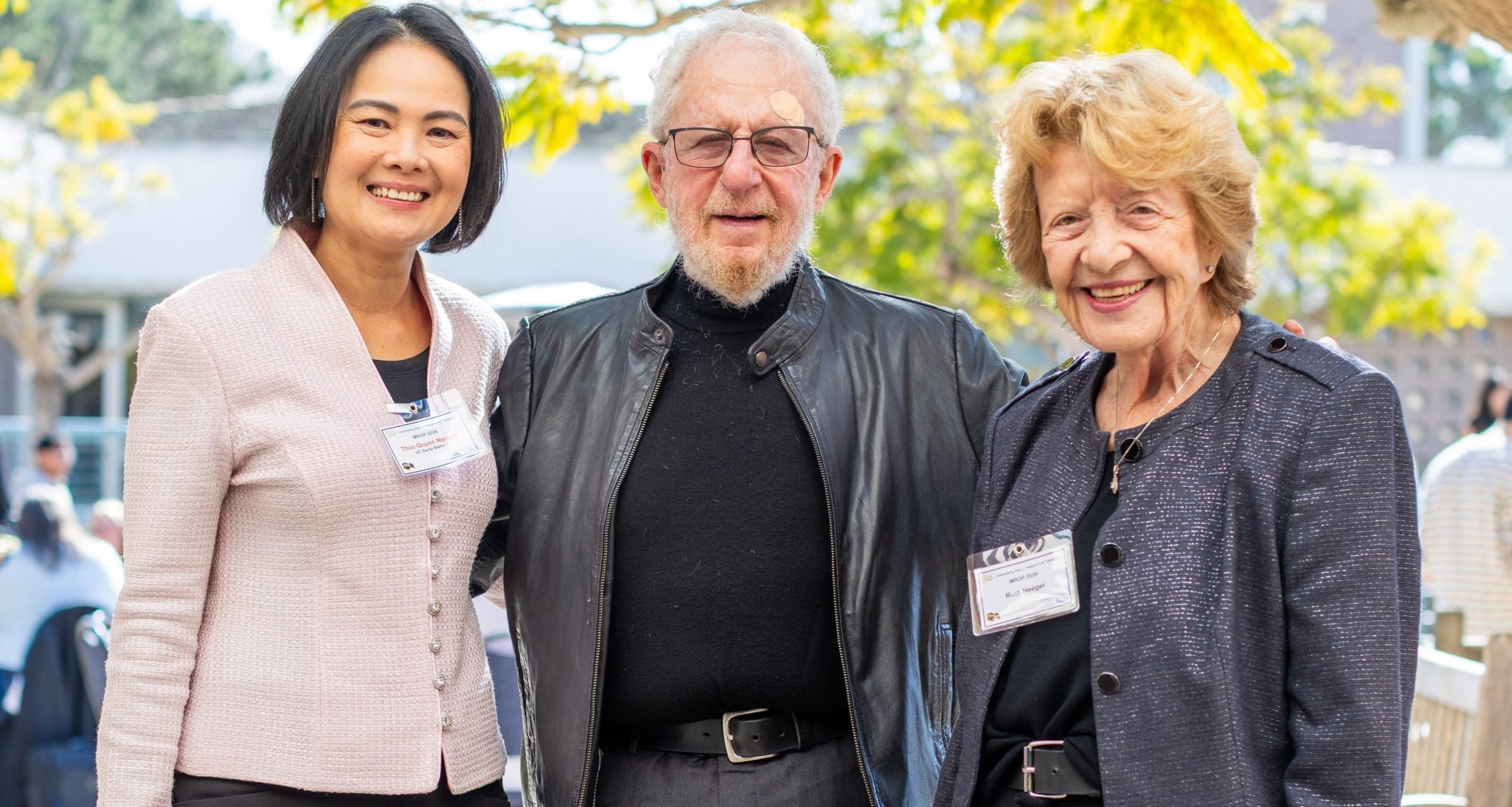 three people standing facing viewer