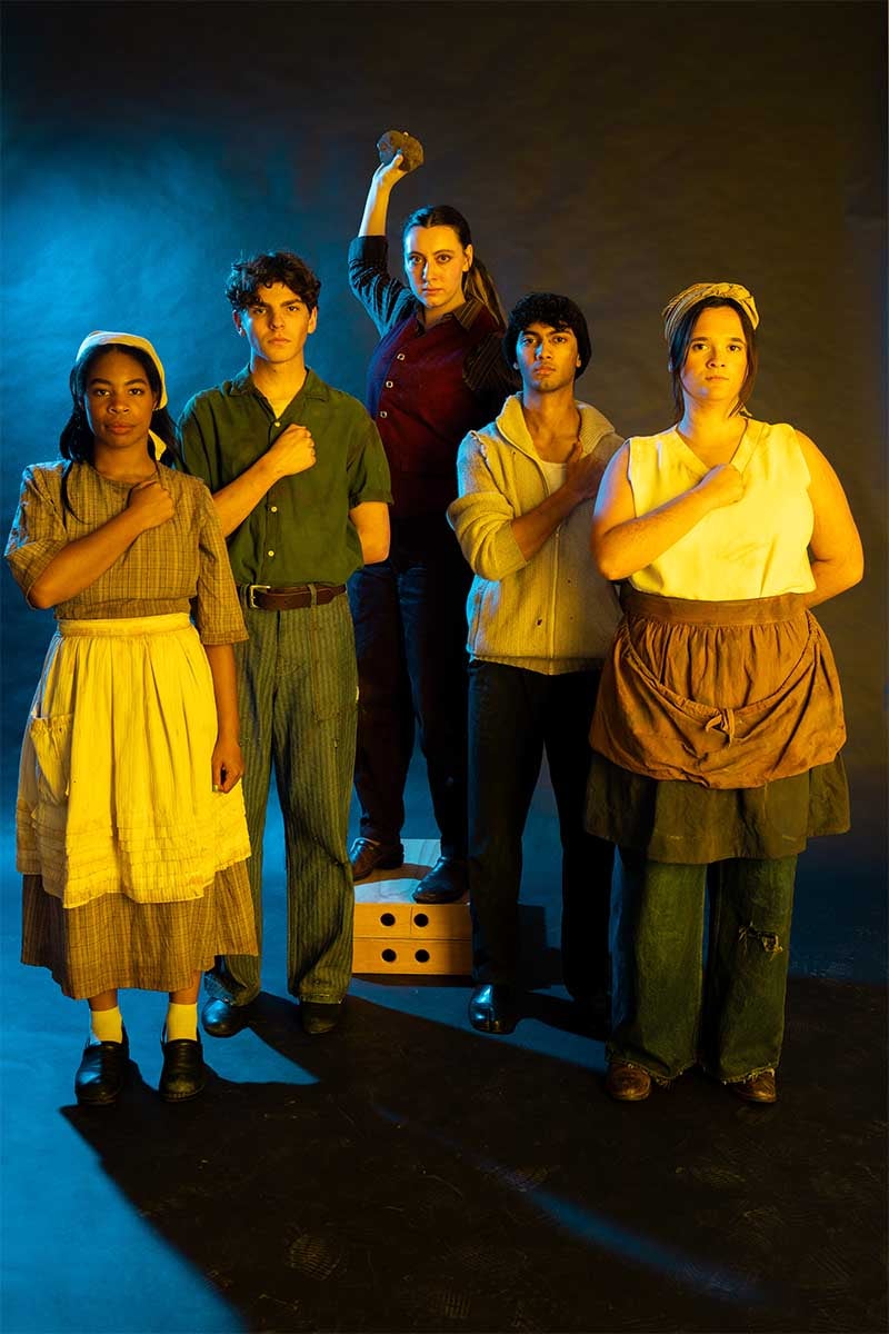 Five adults in farmers attire holding their fists across their chests