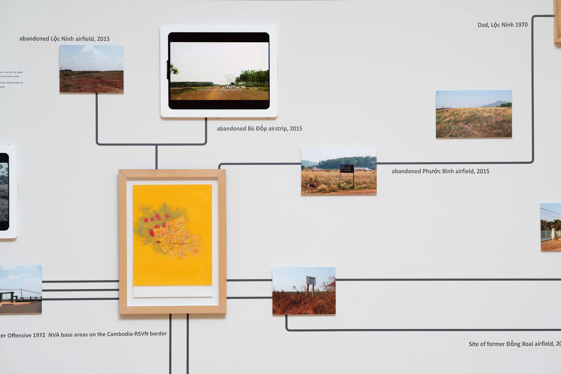 large wall with framed maps and landscape photography connected by black lines like an organizational chart