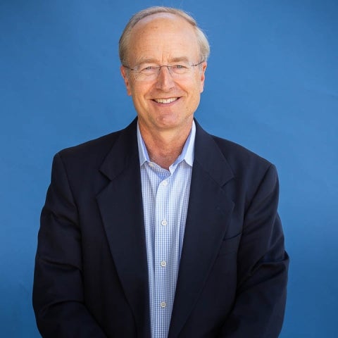 John Bowers in a dark suit with a blue shirt, wearing eyeglasses