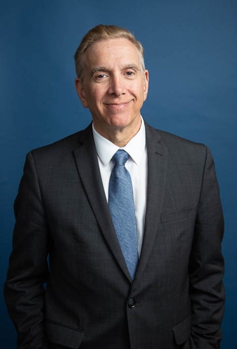 Joseph Incandela wearing a dark suit with a blue tie