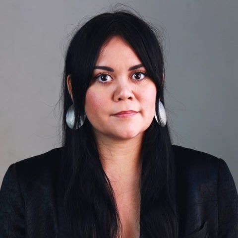 Sarah Rosalena  wears silver earrings and a black top