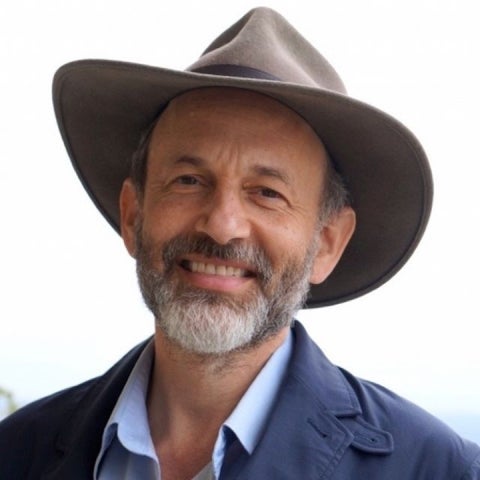 Mark Sherwin wears a wide-brimmed hat and a dark blue blazer