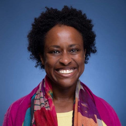 Jean Beaman wears a multicolored scarf in front of a blue background