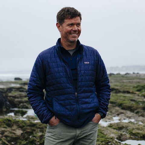 Ian Walker stands outside wearing a blue coat