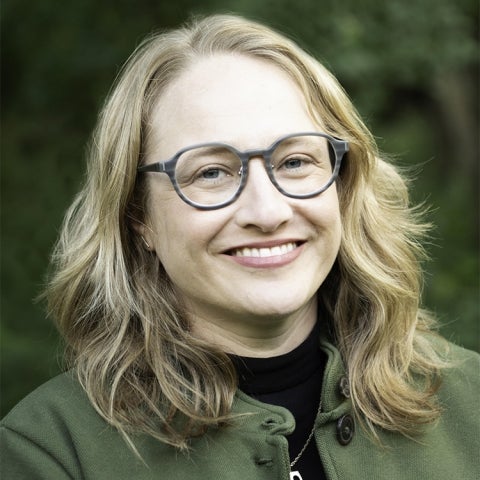 Dana Kornberg wears a green jacket over a black shirt