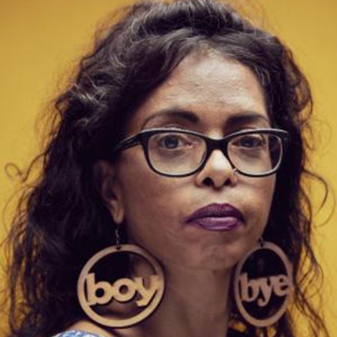 Omise'eke Tinsley wears glasses and earrings that say 'boy' and 'bye'