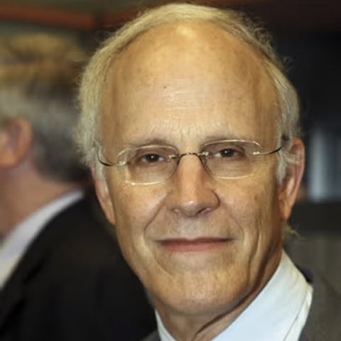 David Gross wears glasses and a dark suit
