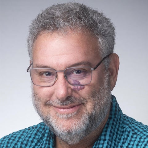 Irwin Appel wears a blue checkered shirt and glasses