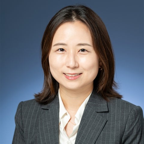 Grace Han wears a pinstriped blazer and white shirt