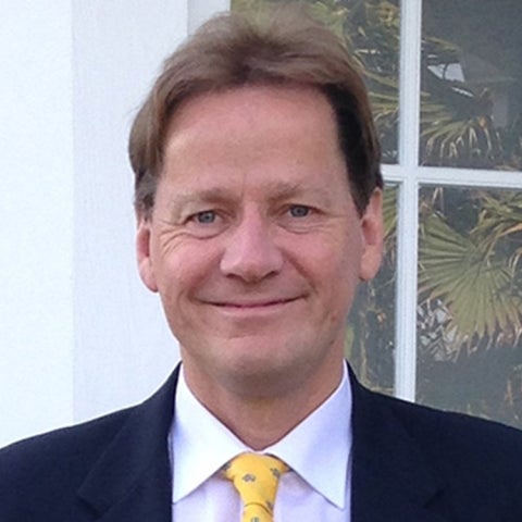 Eckart Meiburg wears a dark suit with a yellow tie