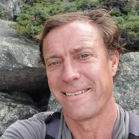 David Patterson stands in front of some boulders