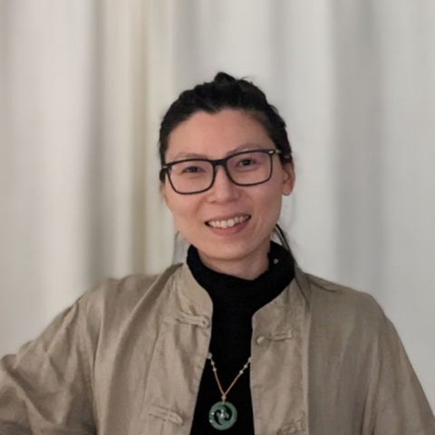 Xiao Lio wears a beige coat over a black sweater