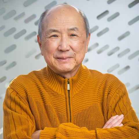 Alan Liu wears an orange zip-up sweatshirt and has his arms crossed