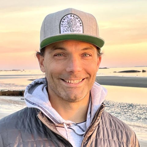 Peter Kedron wears a down coat and hat at the beach